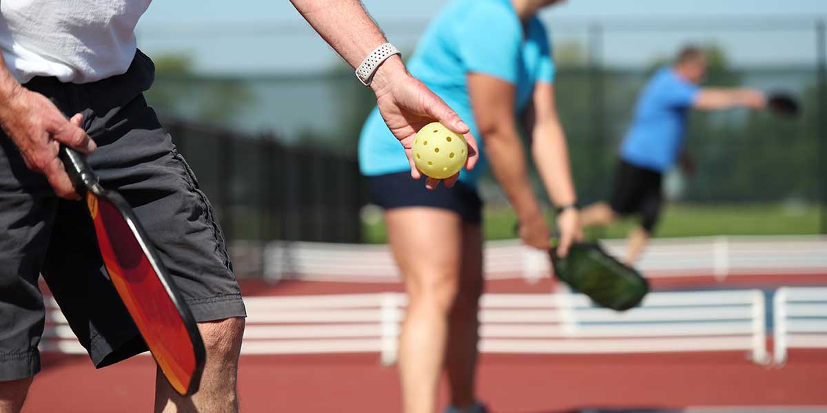 pickleball balls , pickleball players on a pickleball court in the sun